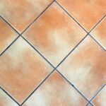 Immagine di aceto versato su fughe di piastrelle per pulizia e sbiancamento.