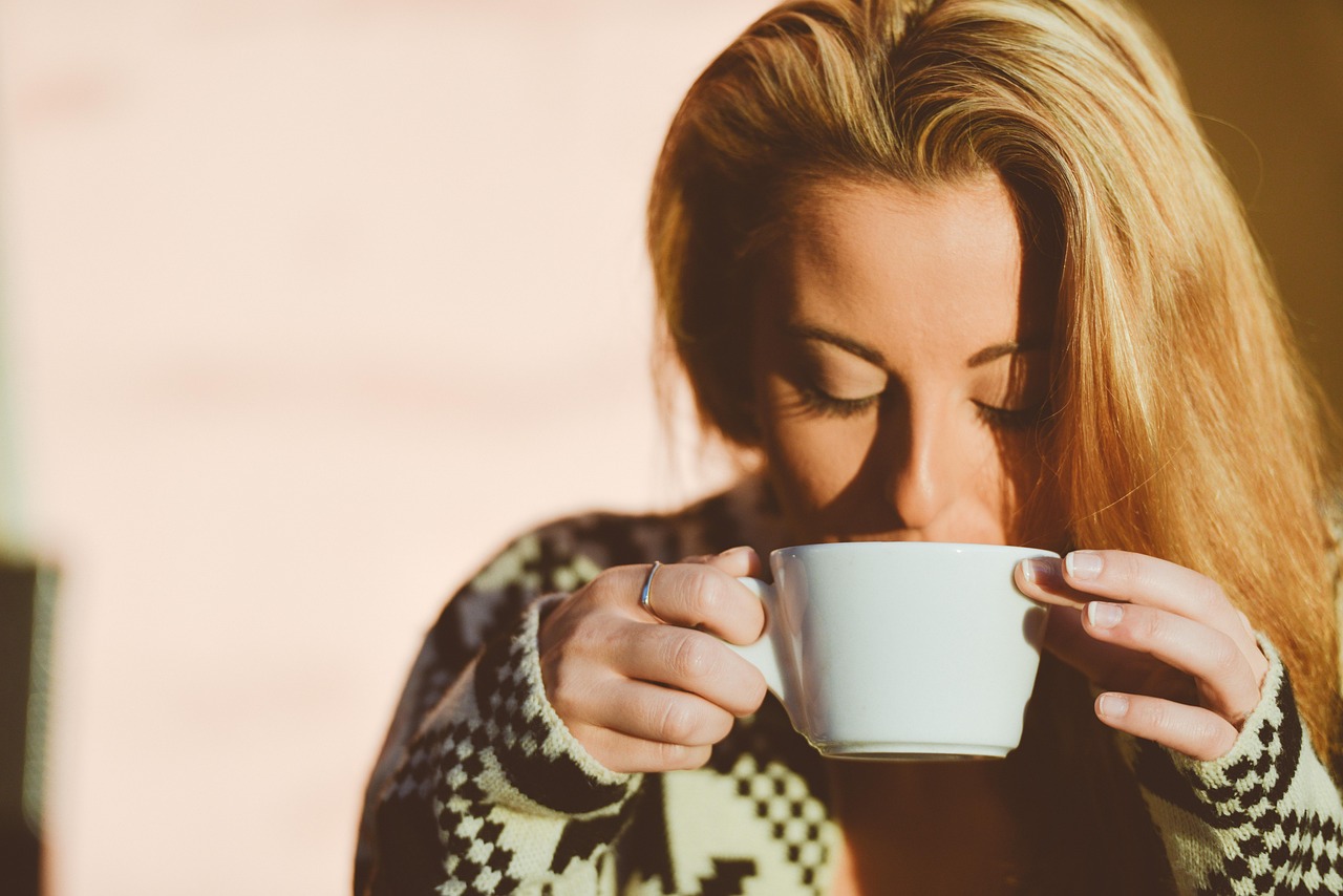 Tazza di caffè fumante accanto a un libro, simbolo della relazione tra caffè e vitamina D.