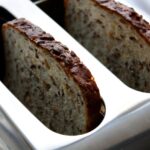 Fette biscottate integrali su un tavolo con ingredienti freschi per una colazione sana e nutriente.