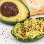 Avocado tagliato a metà con nocciolo, simbolo di salute e abbassamento del colesterolo alto.