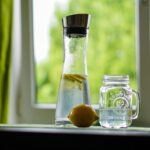 Due bicchieri d'acqua fresca su un tavolo al risveglio, simbolo di benessere e idratazione.