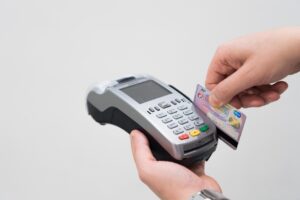 Commercianti che utilizzano un POS per i pagamenti, illustrazione delle nuove regole.
