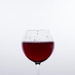 Bottiglia di vino rosso con bicchiere, simbolo di salute cardiaca e scelta ottimale per il benessere.