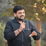 Concorrente di Affari Tuoi durante il gioco, con pacchi e pubblico entusiasta.