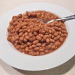 Scatola di fagioli con etichetta evidenziata, simbolo di avvertimento per salute e benessere.