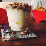 Immagine di un vasetto di yogurt con frutta fresca, simbolo di salute intestinale e benessere.