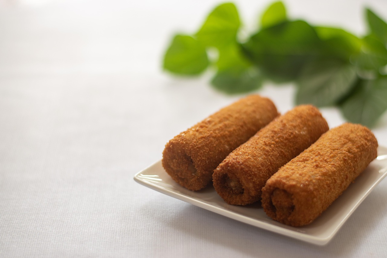 Involtini di pollo farciti, serviti su un piatto decorato con erbe fresche.