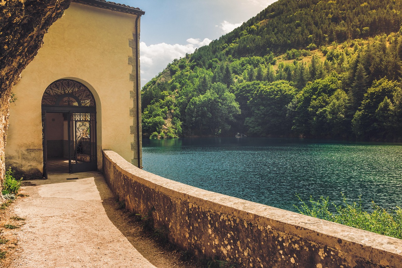 Lago segreto in Piemonte circondato da boschi incantati e riflessi magici nell'acqua.