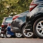 Meccanico controlla un'auto durante una revisione, evidenziando la nuova scadenza per la revisione.