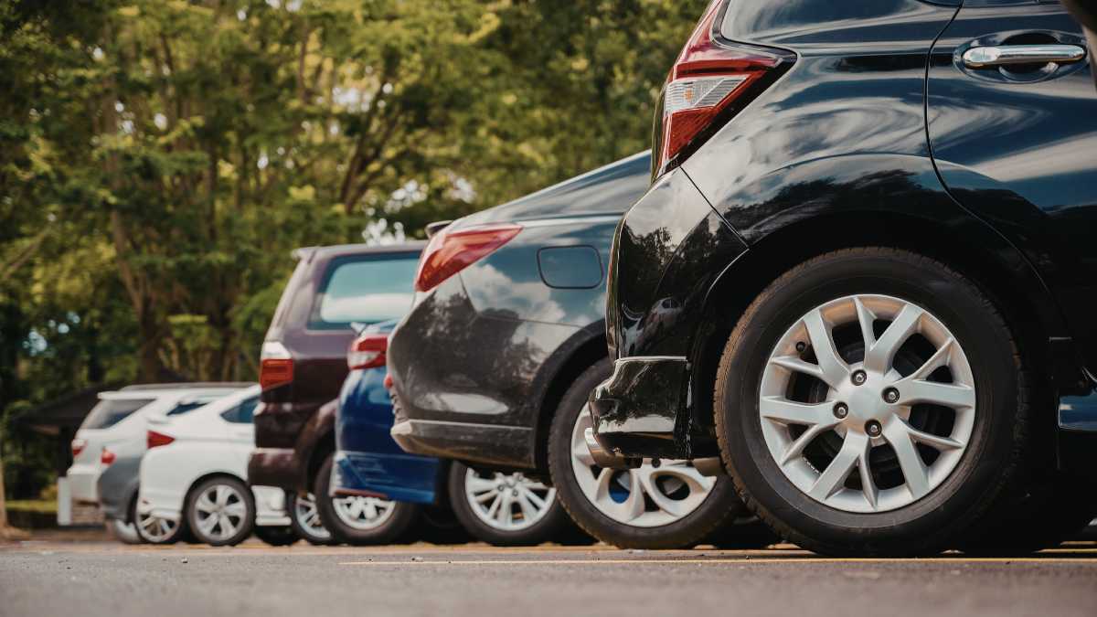 Meccanico controlla un'auto durante una revisione, evidenziando la nuova scadenza per la revisione.